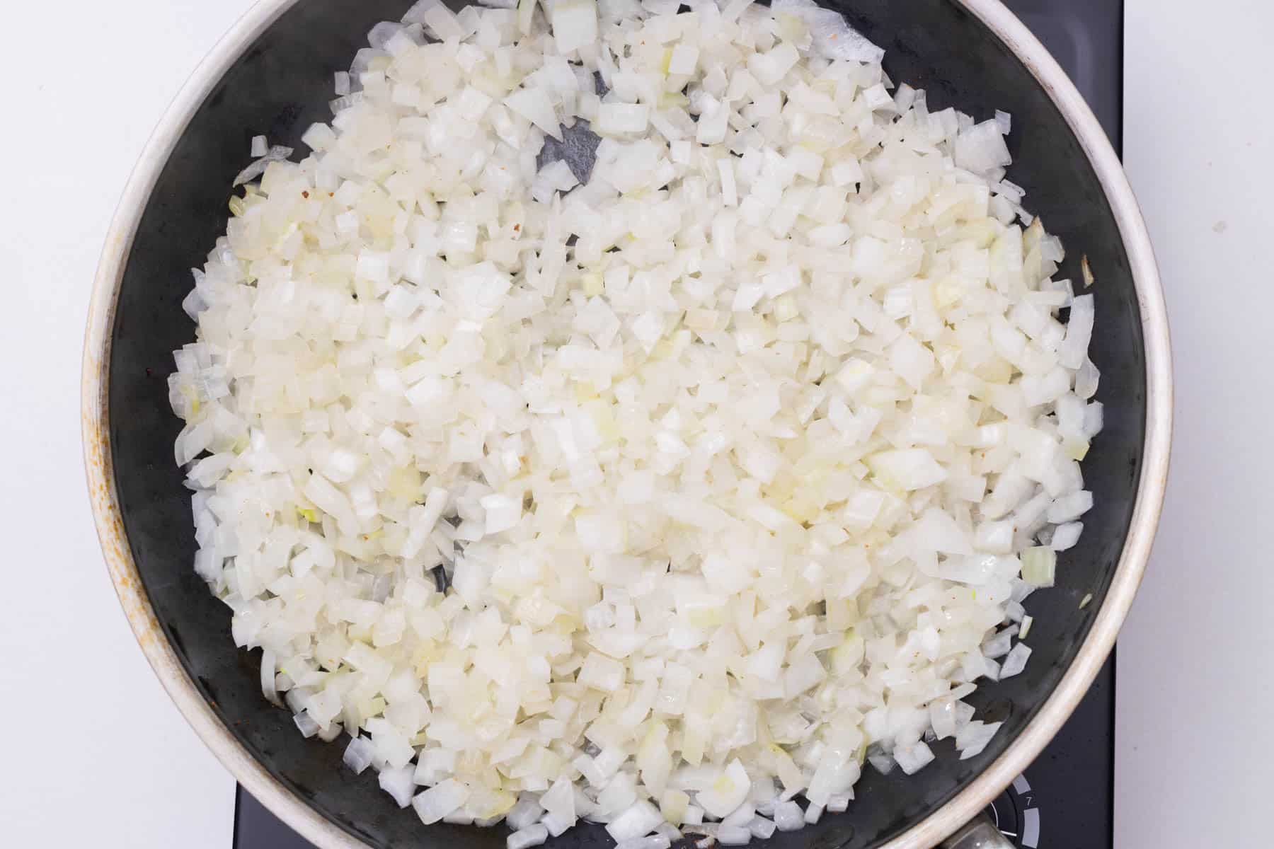 Diced onoins are added to a skillet.