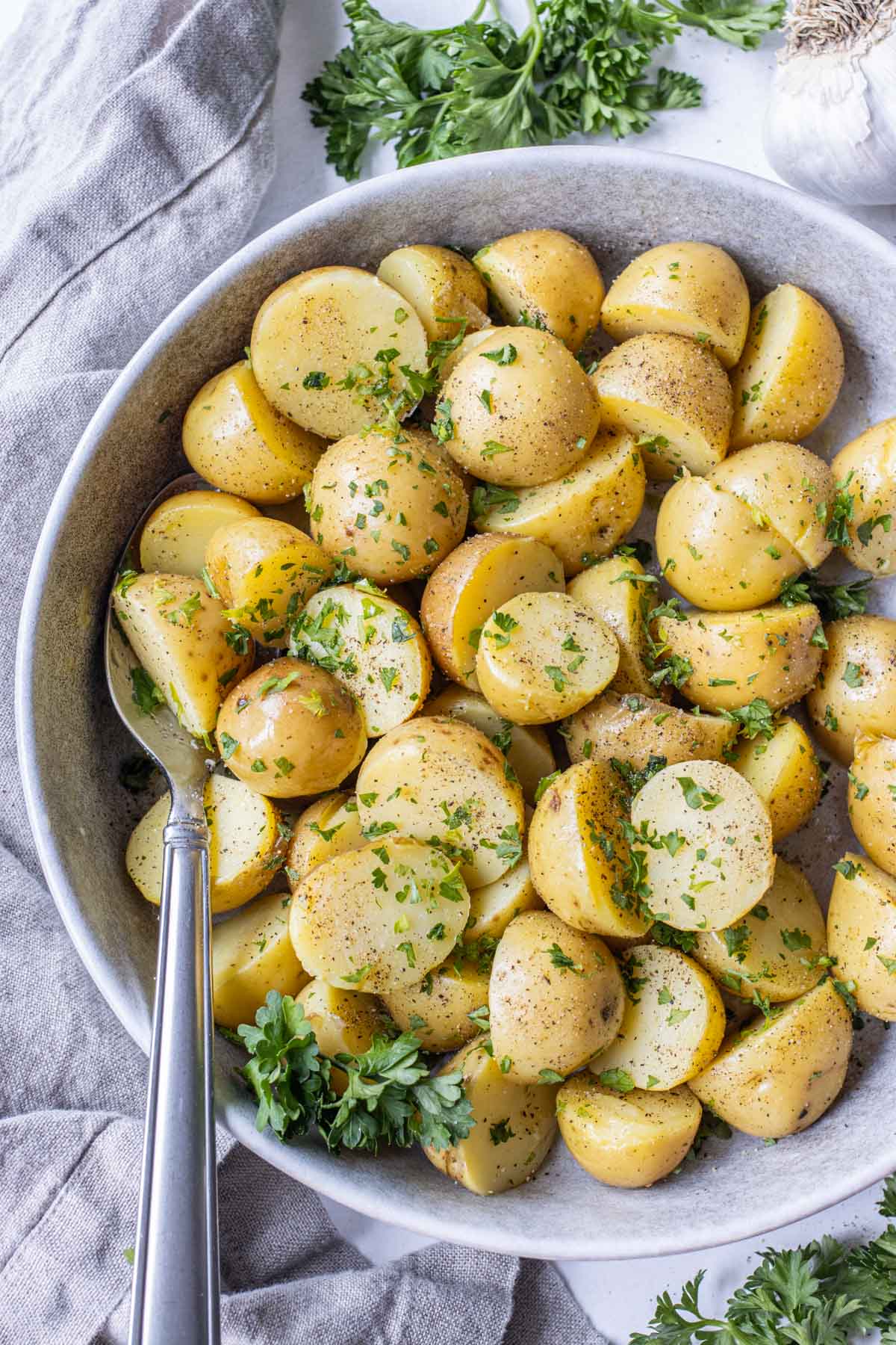 A bowl full of boiled Yukon gold potatoes with parsley.