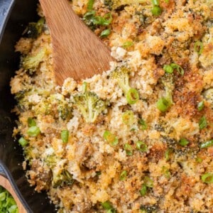 A wooden spoon is used to serve ground turkey broccoli cheese rice.