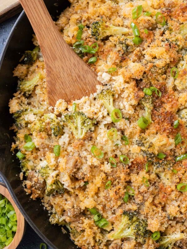 A wooden spoon is used to serve ground turkey broccoli cheese rice.