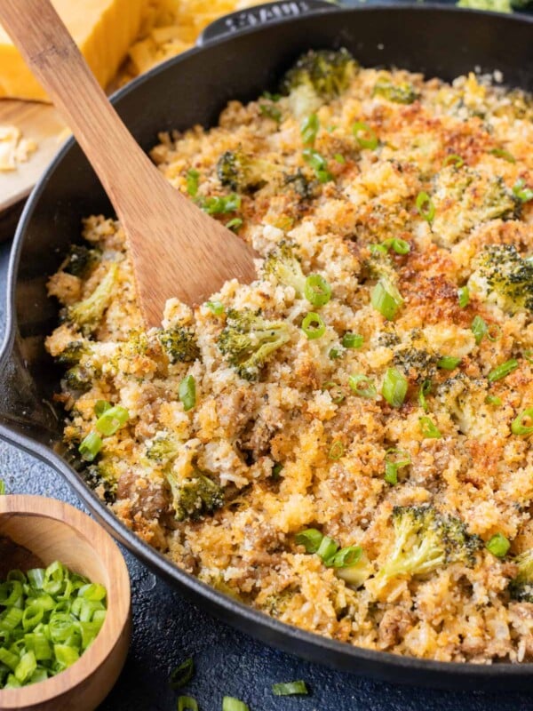 A wooden spoon is used to serve the broccoli rice mixture.