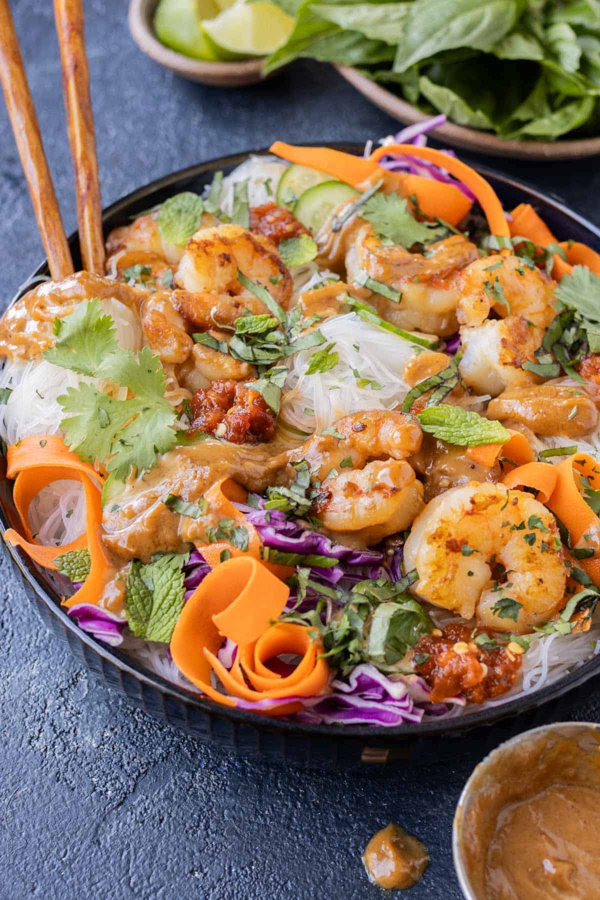 A deconstructed spring roll is served in a bowl with shrimp and fresh veggies.