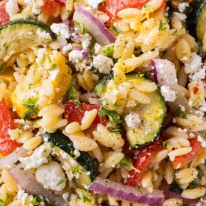 The lemon orzo pasta salad is tossed in a large bowl.