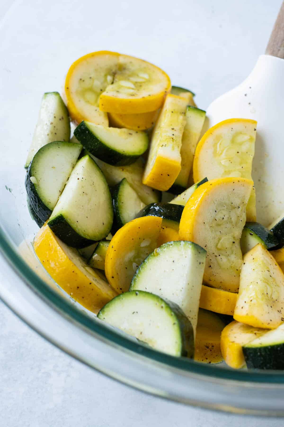 Squash is sliced and seasoned.