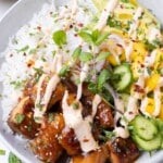 Teriyaki salmon bowls are filled with coconut milk, mangoes, and sriracha mayo.