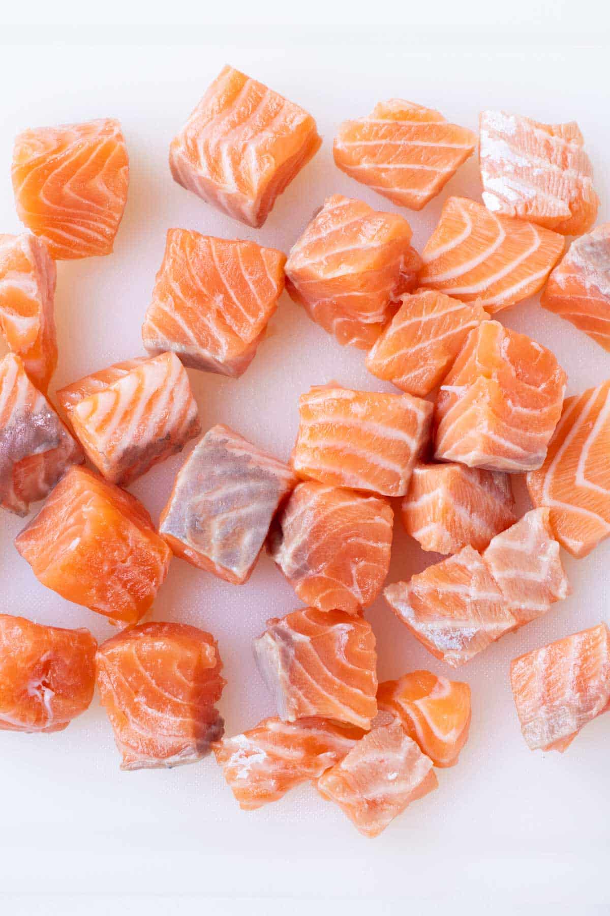 Salmon is cut into bite-sized pieces.