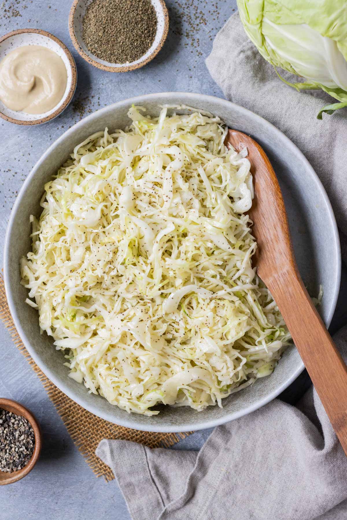 Apple cider slaw is served with a wooden spoon.