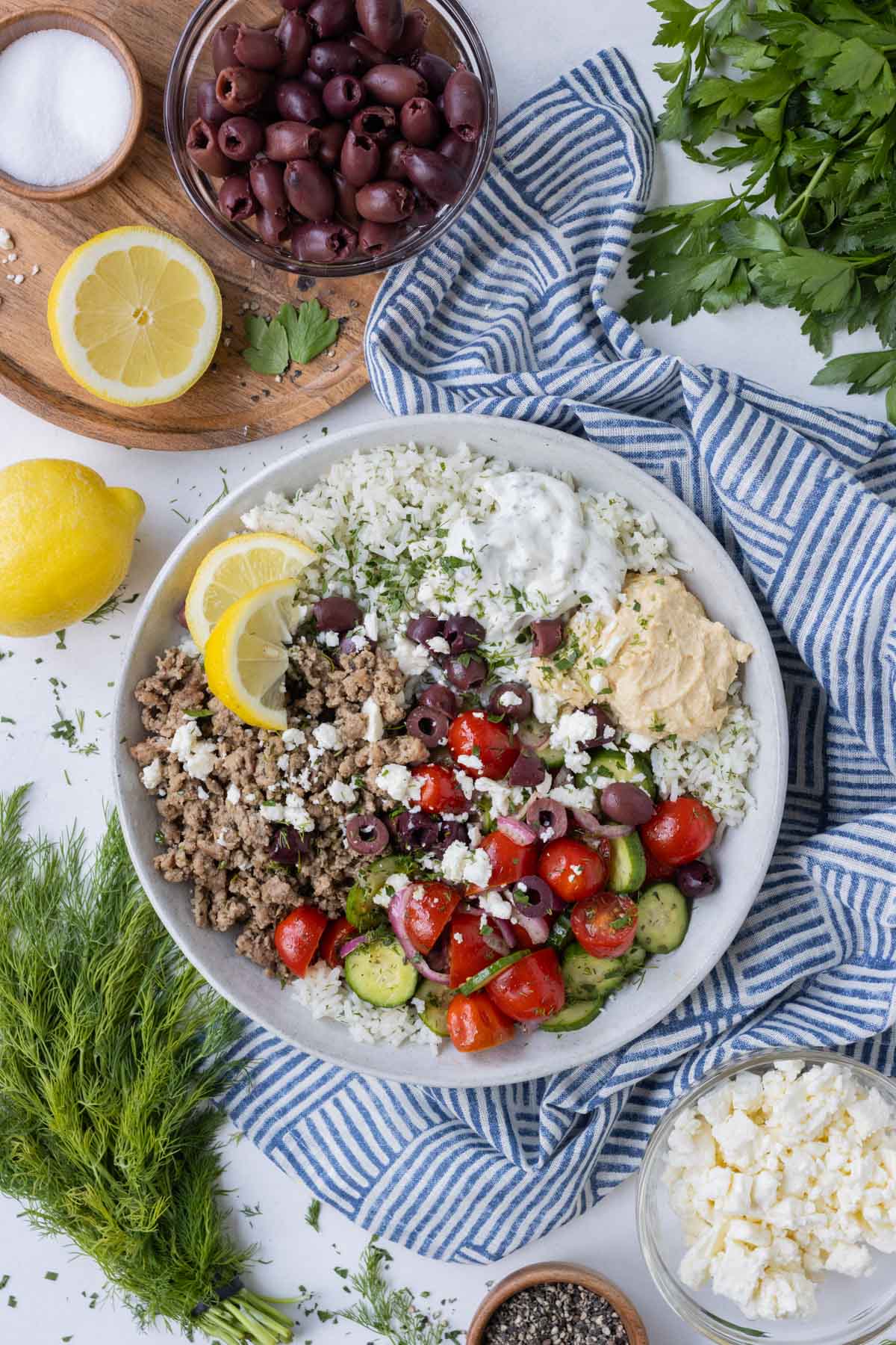 Greek turkey rice bowls are served in a white bowl with a side of fresh lemons.