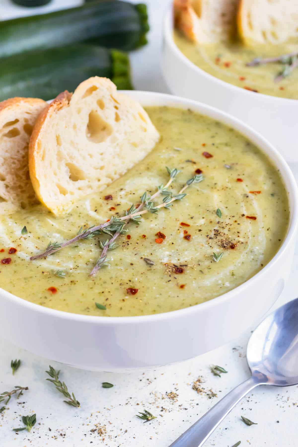 Zucchini soup with fresh herbs and bread.