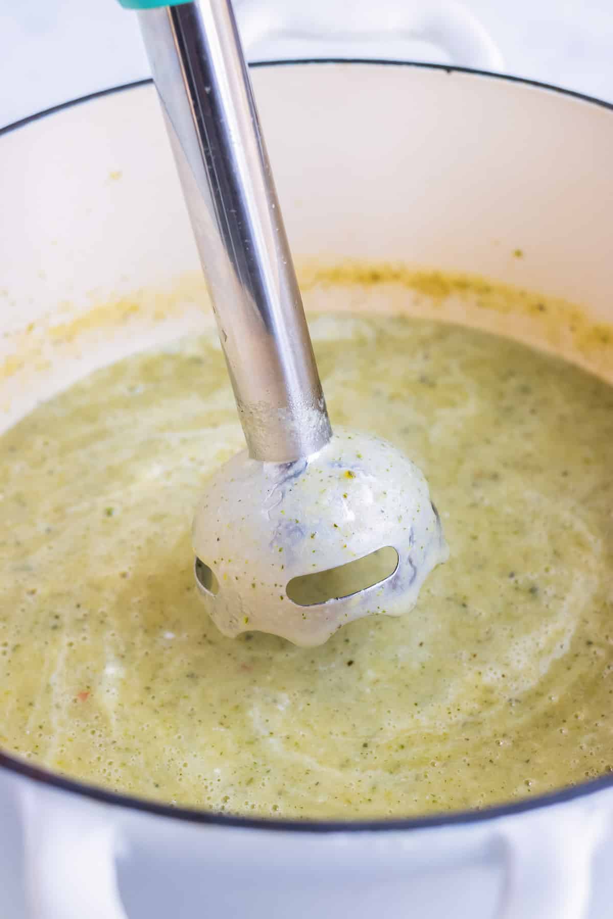 An immersion blender is used to create a smooth soup.