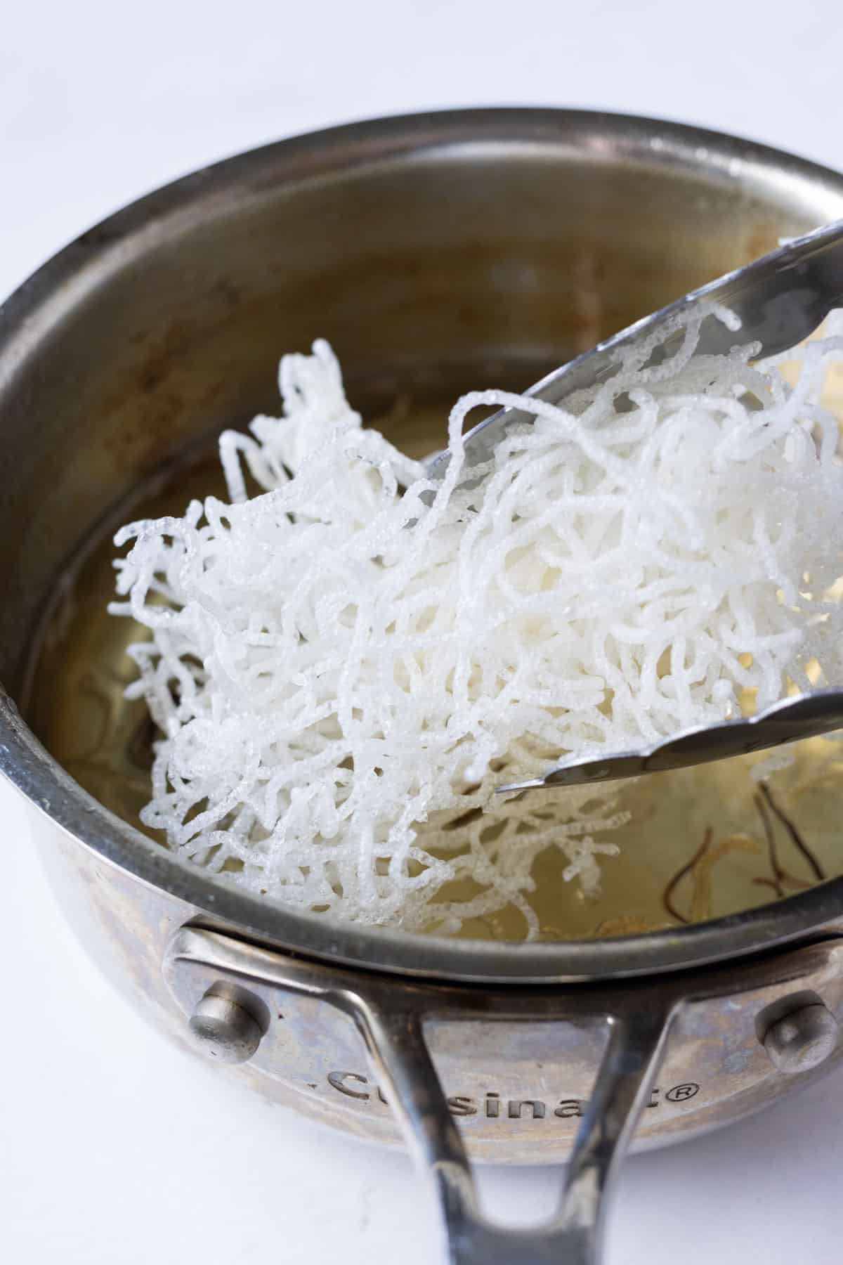 Rice noodles are fried until crispy.