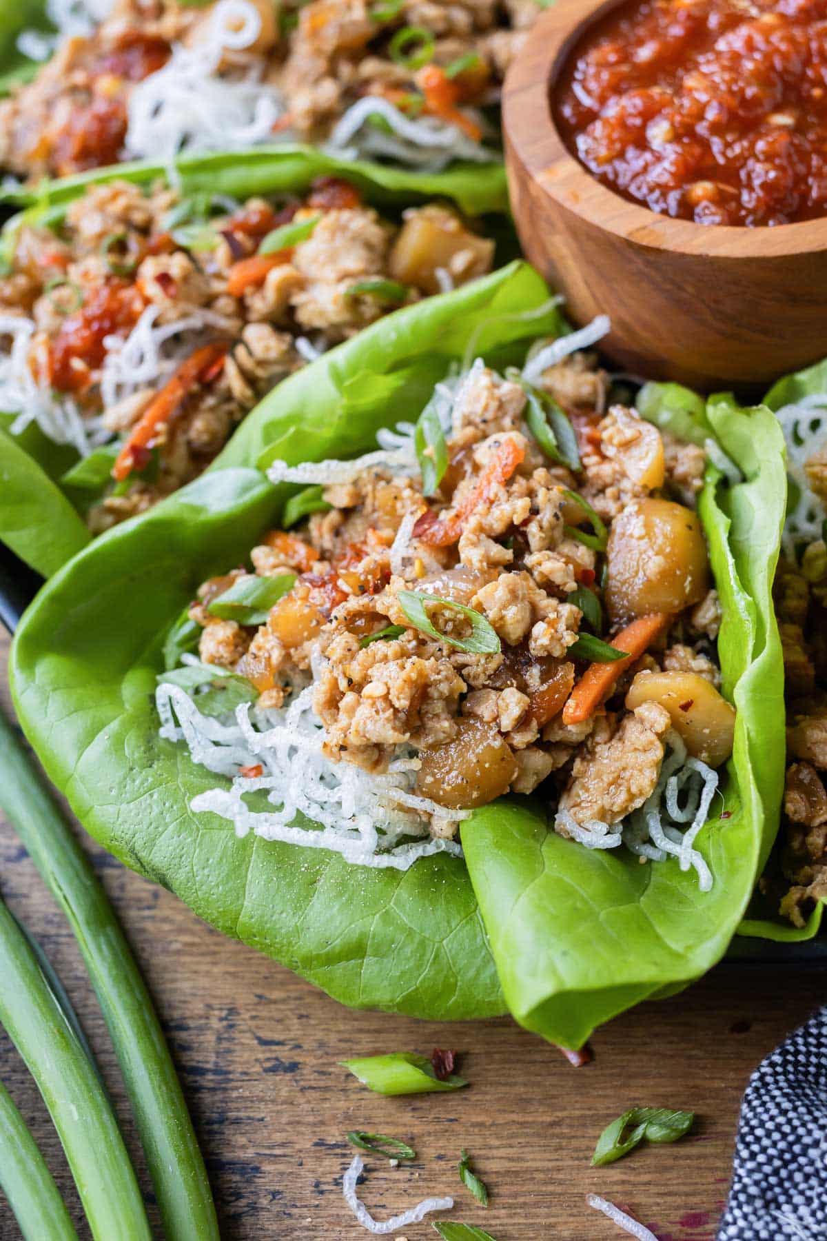 Chicken lettuce wraps are served with a dipping sauce.