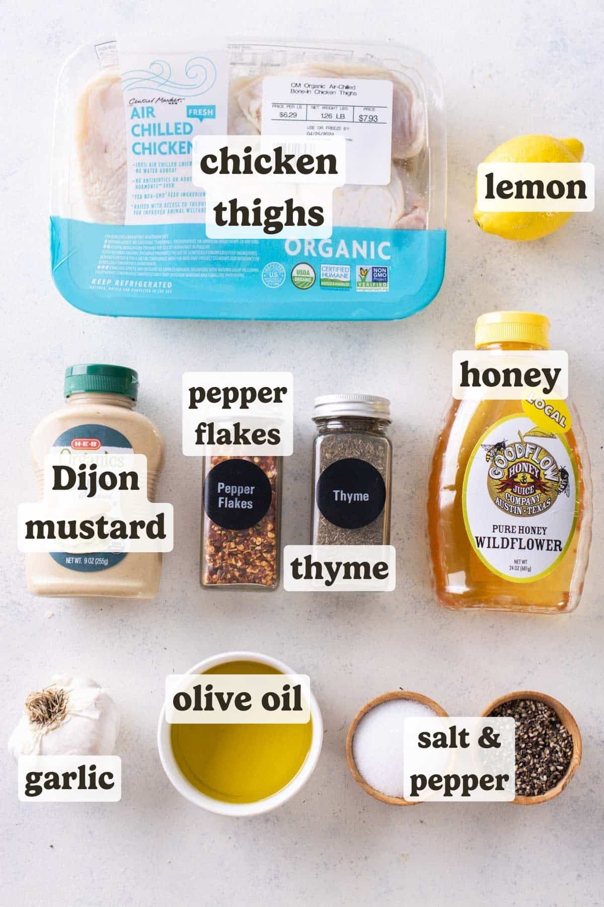 The ingredients needed for a baked honey mustard chicken thighs recipe are on a white table.