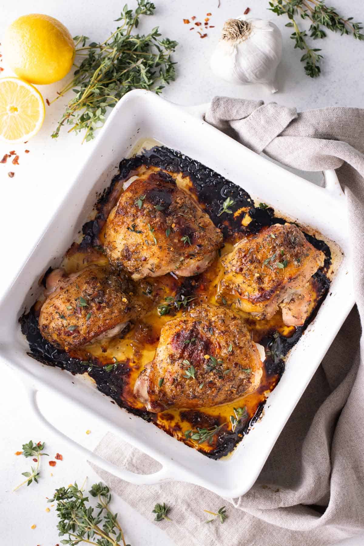 A baking dish full of bone-in honey mustard chicken thighs.