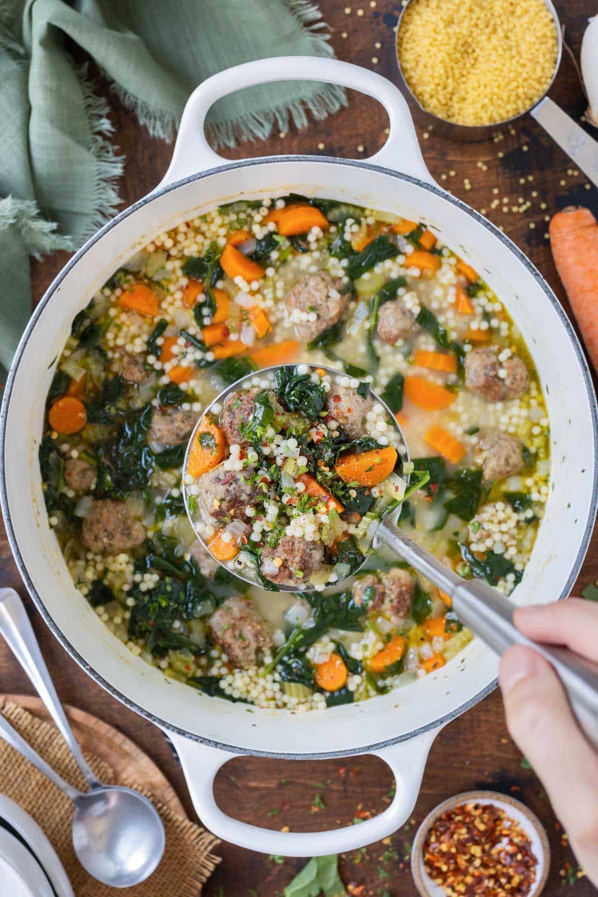 A ladle is used to serve the Italian wedding soup.