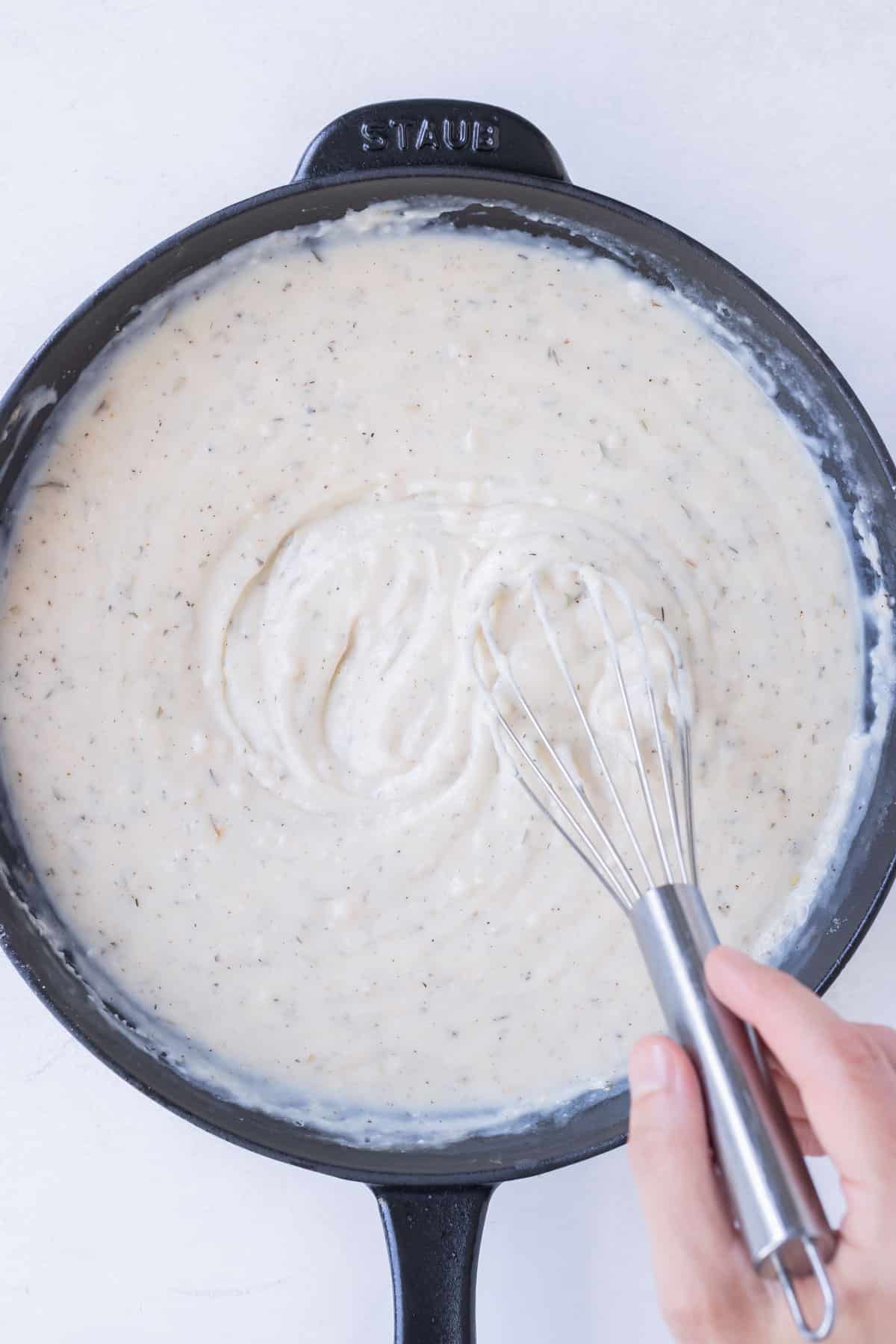 A creamy sauce is made in a skillet.