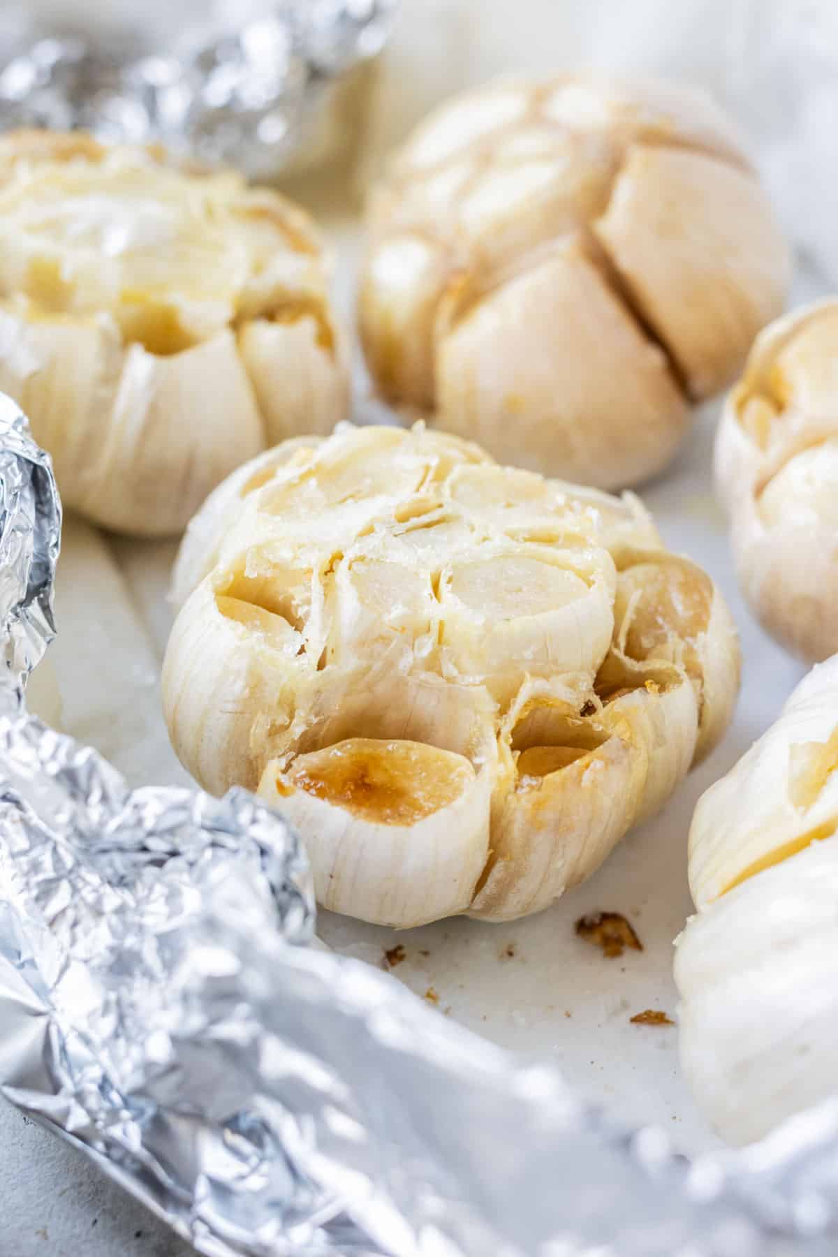 Air fryer roasted garlic on a layer of parchment paper and foil.