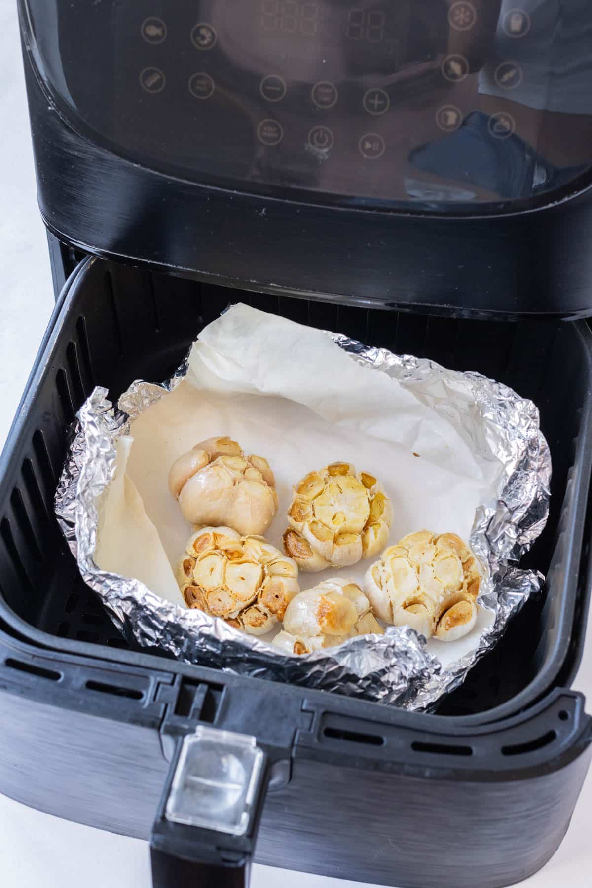 Garlic cloves are roasted in the air fryer.