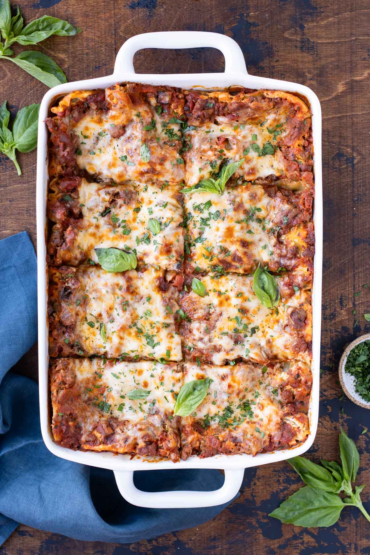 Easy lasagna is baked in a white casserole dish.