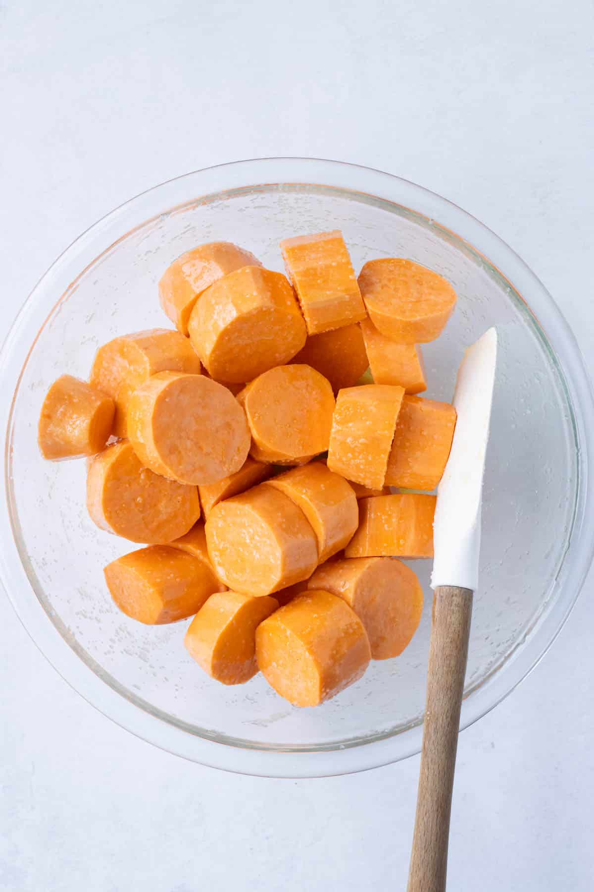 Sliced sweet potatoes are added to a bowl.