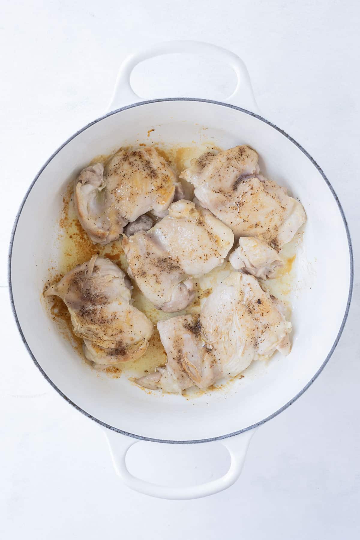 Chicken is cooked in a Dutch oven.