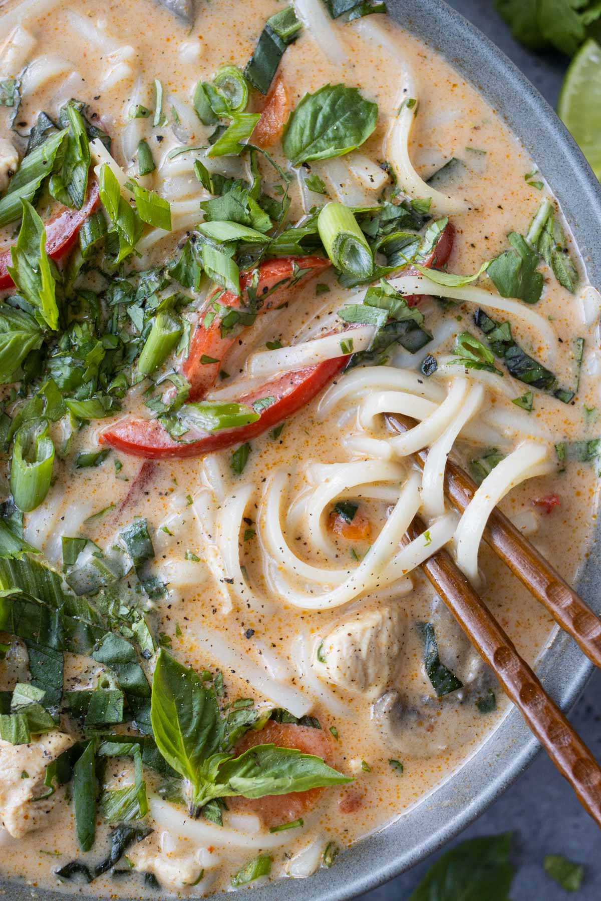 Chopsticks are used to dig into this Thai chicken soup with noodles and fresh herbs.