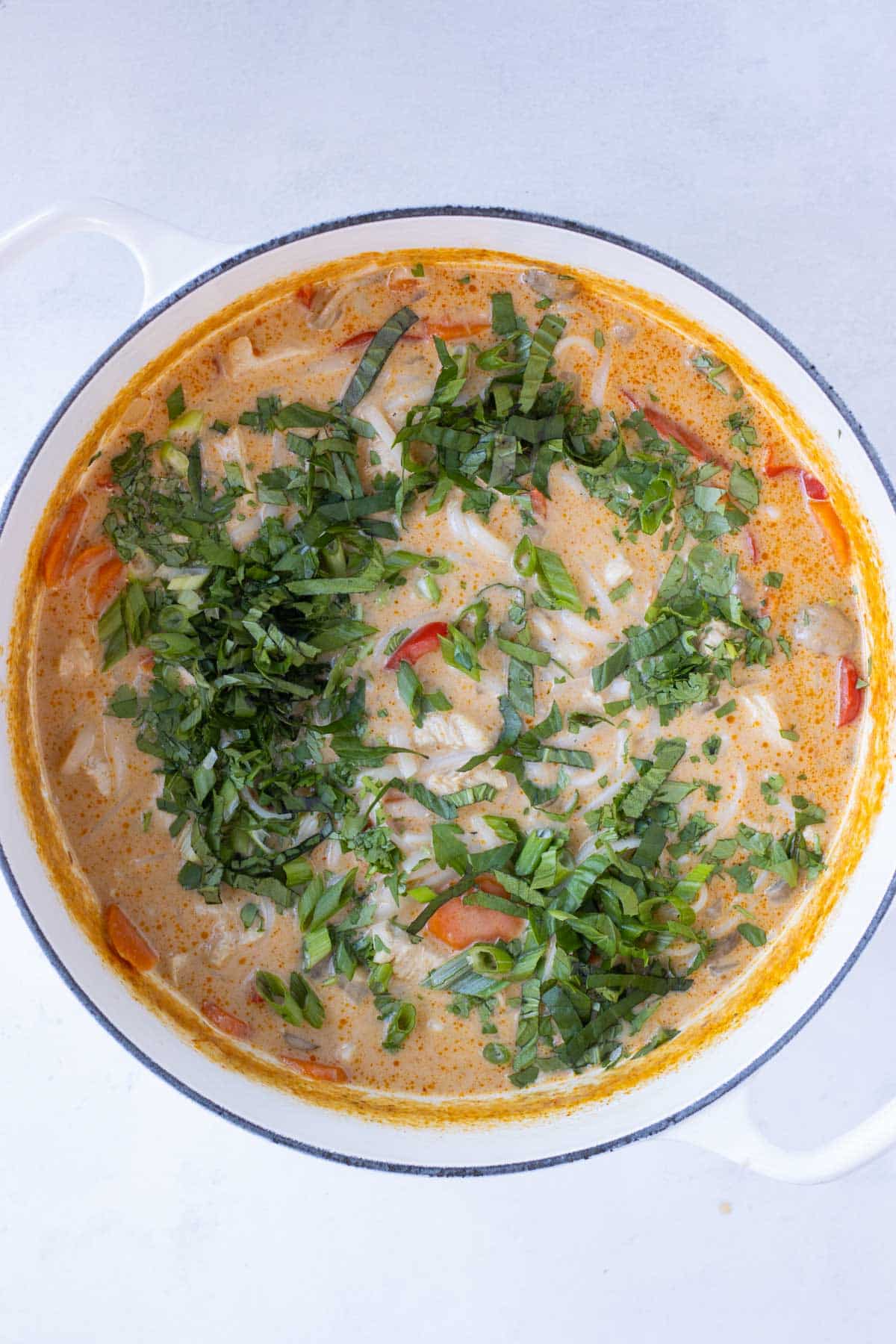 Fresh herbs are added to the Thai soup before serving.