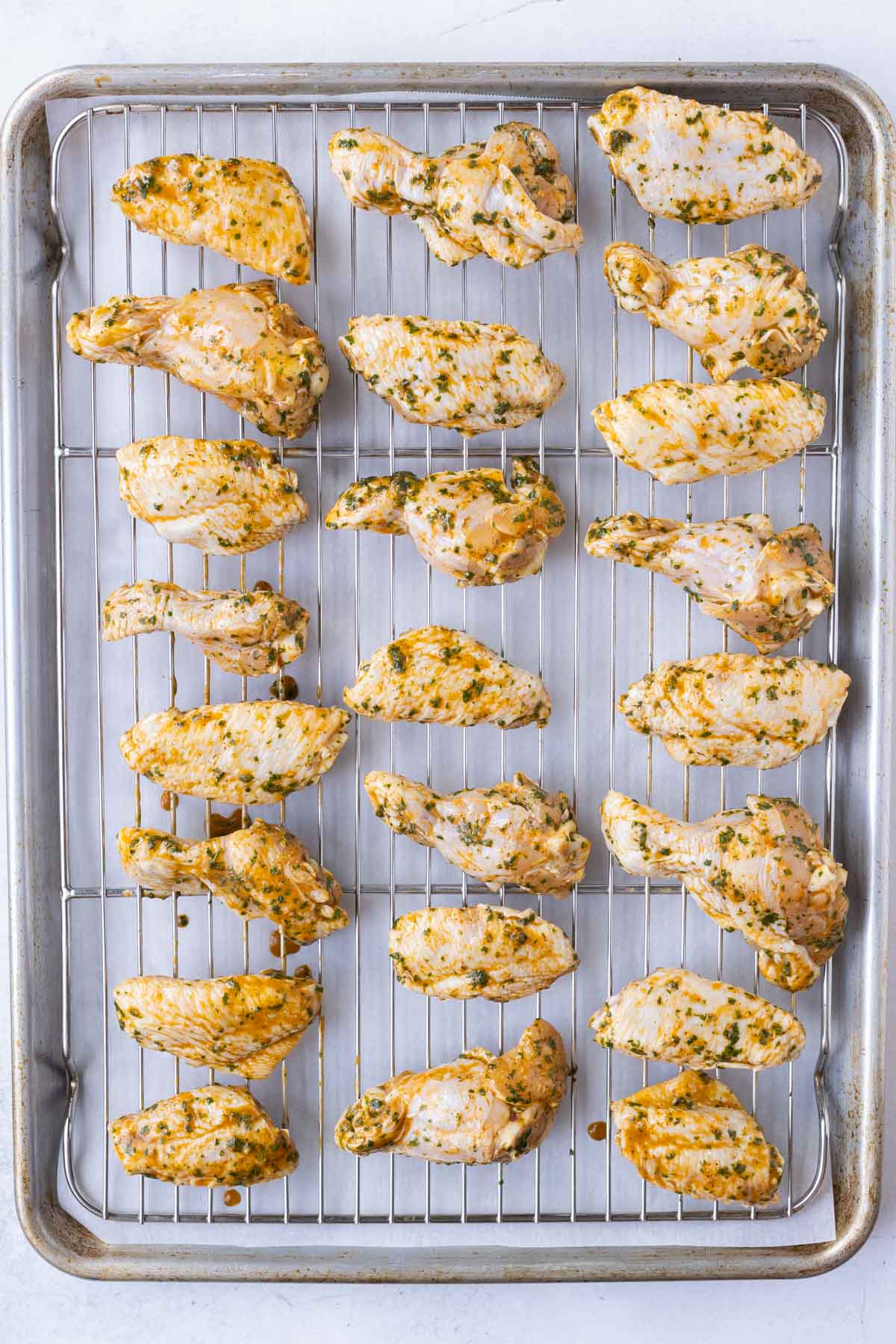 Seasoned wings are baked on a tray.