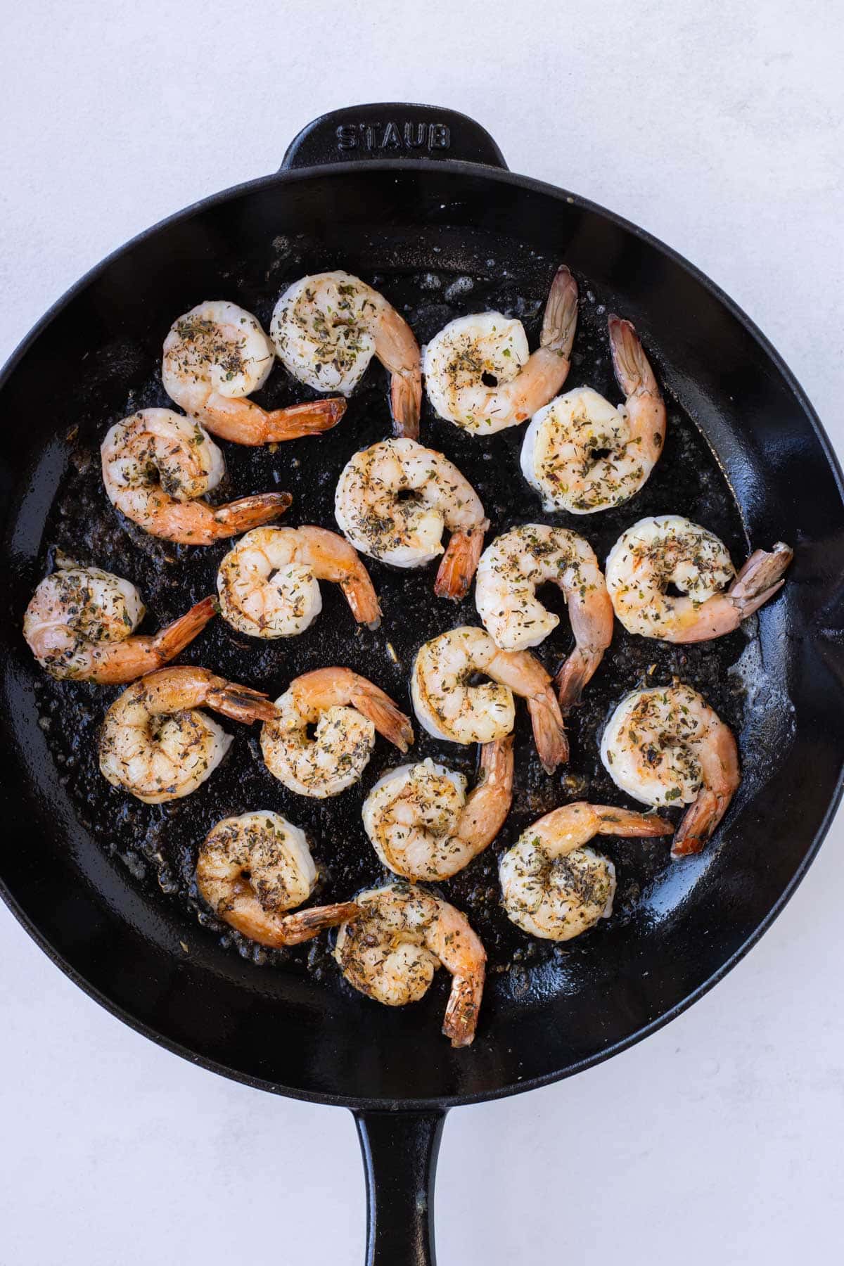 Shrimp is cooked in a skillet.