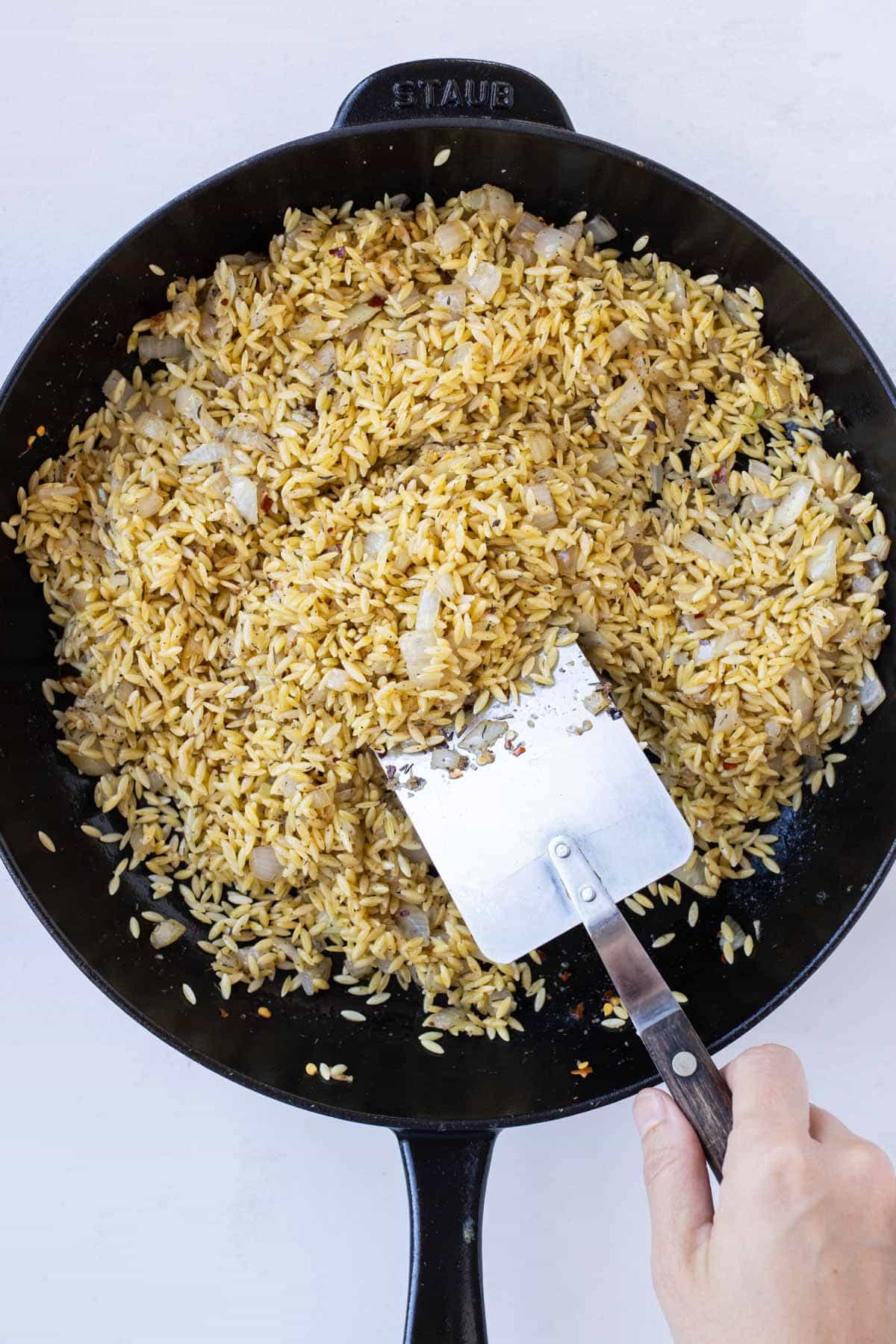 Orzo is toasted in a skillet.