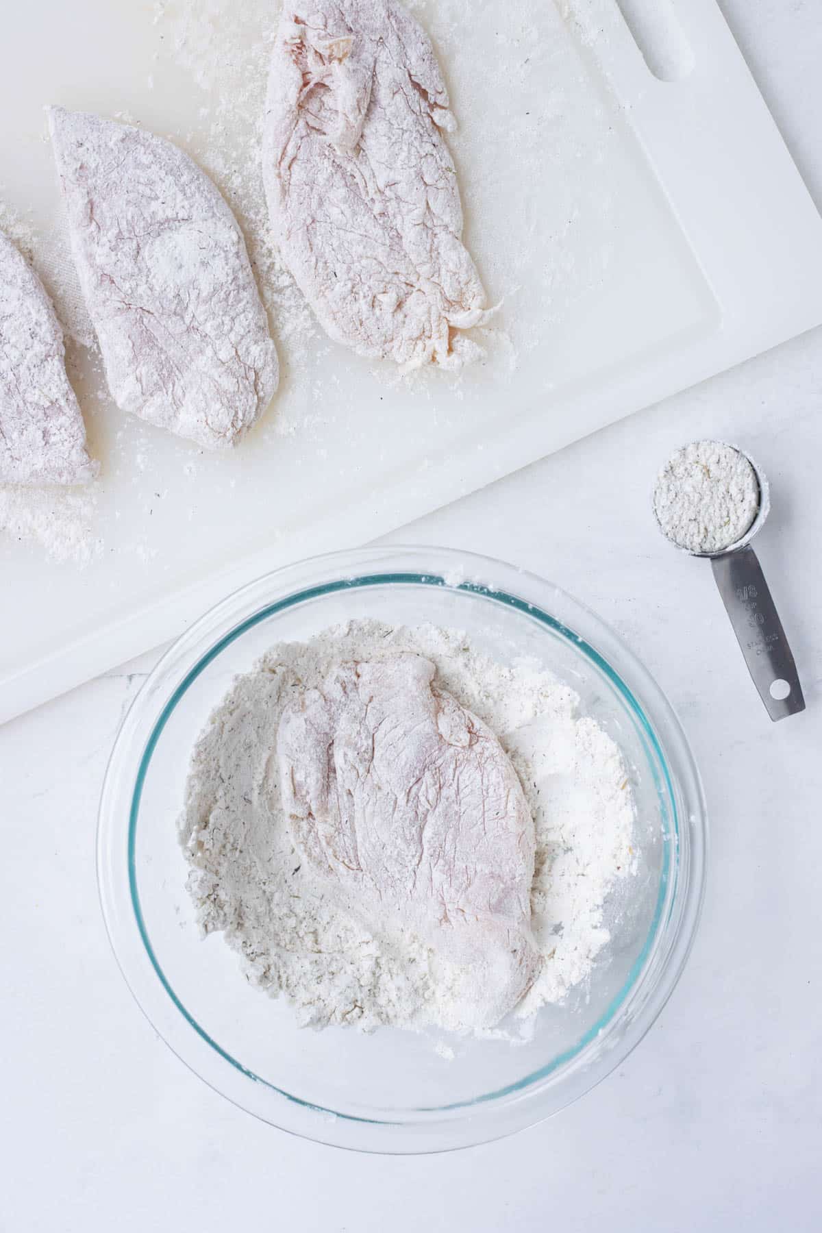 Chicken is pounded thin and dredged in flour.