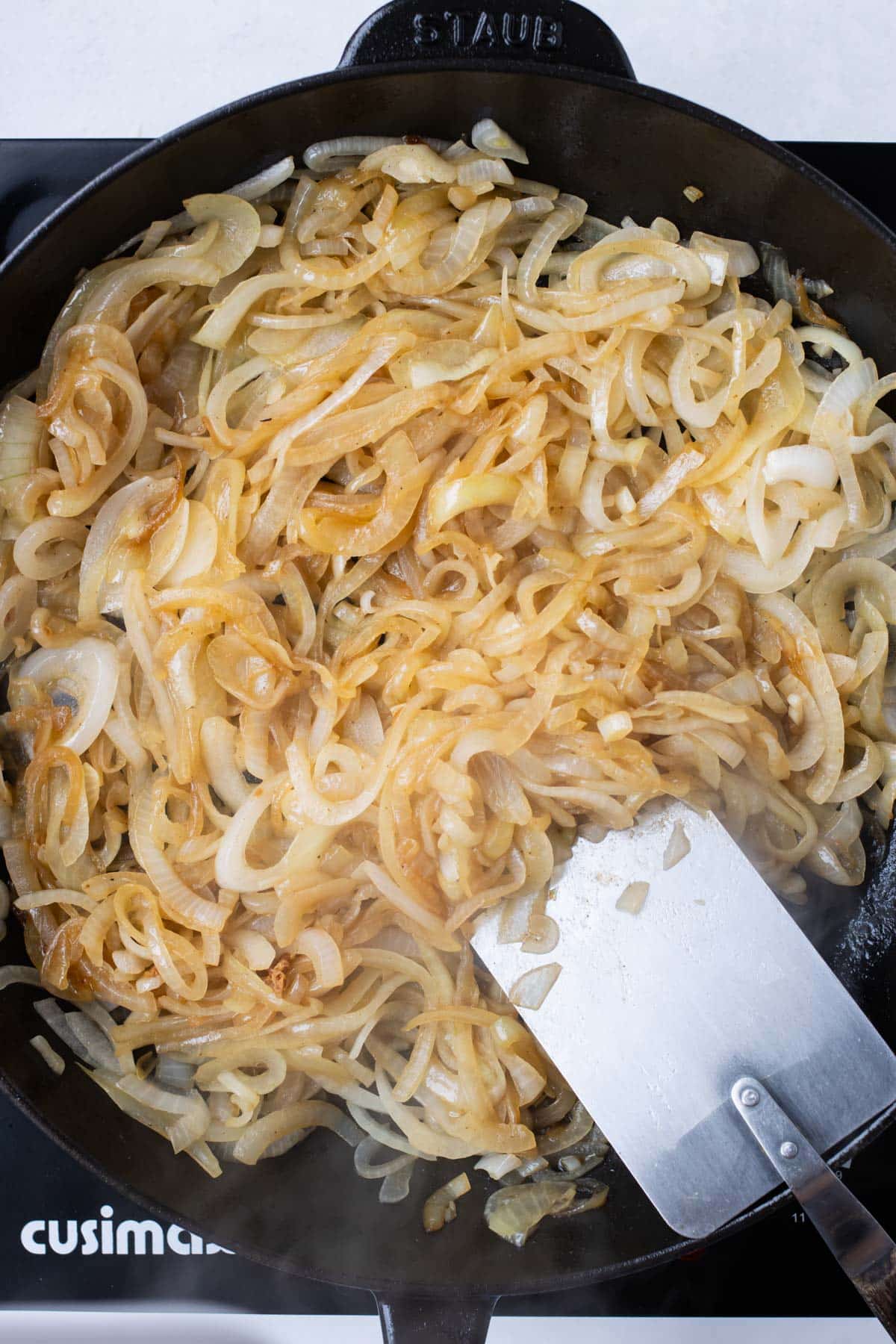 Garlic and broth is added to the caramelized onions.