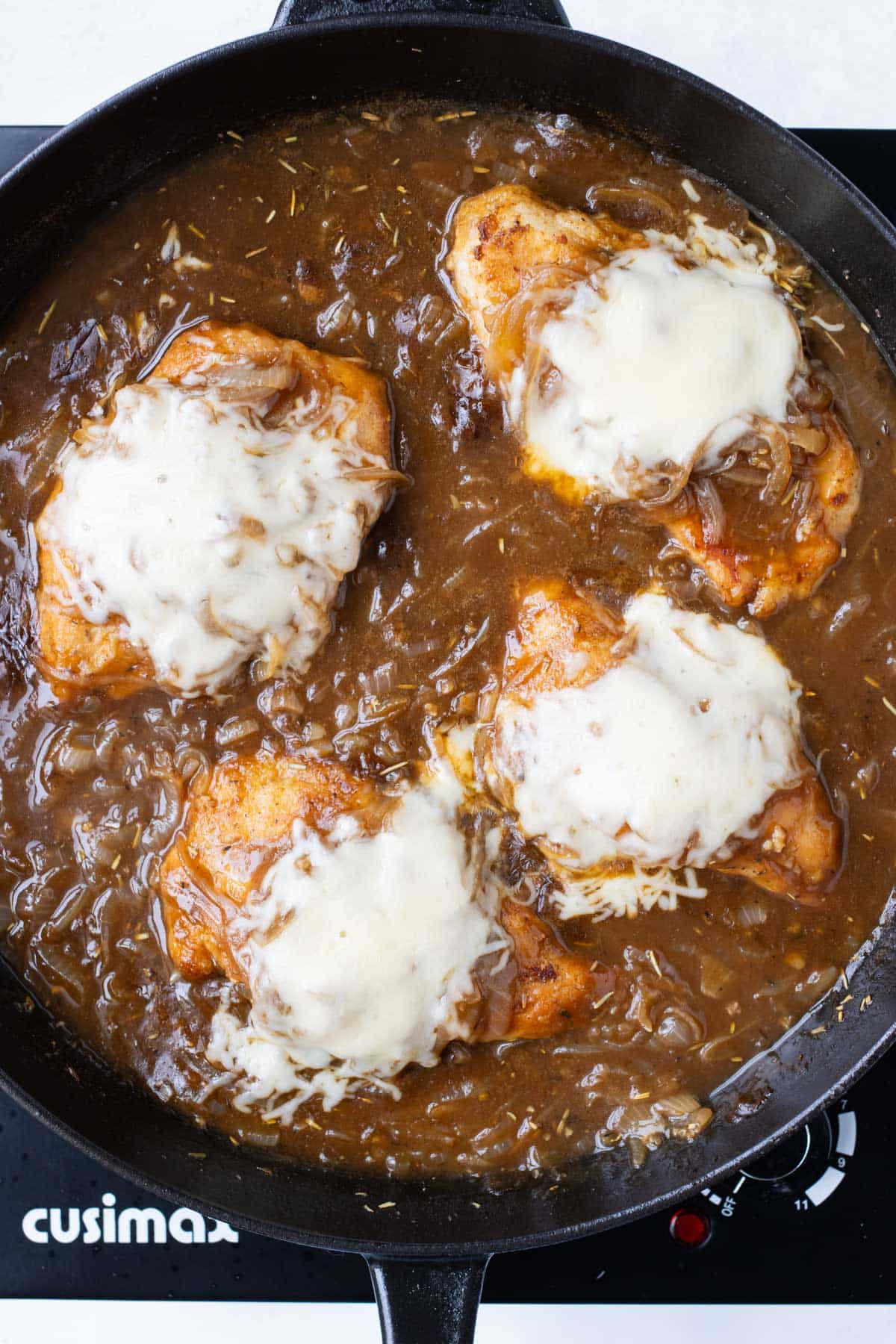 Chicken breasts are topped with Gruyere cheese and cooked a little longer.