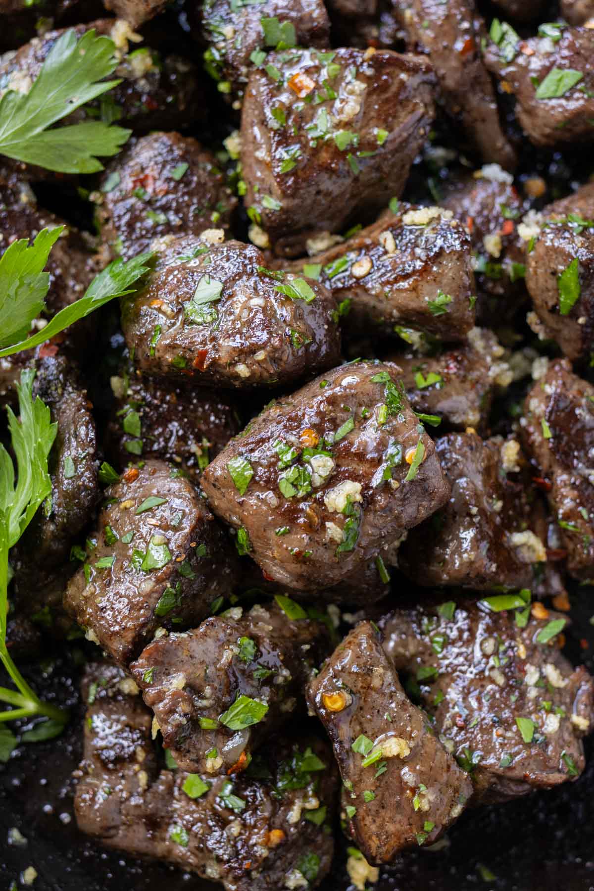 Perfectly seasoned bits of steak are topped with parsley in this garlic butter steak bite recipe.