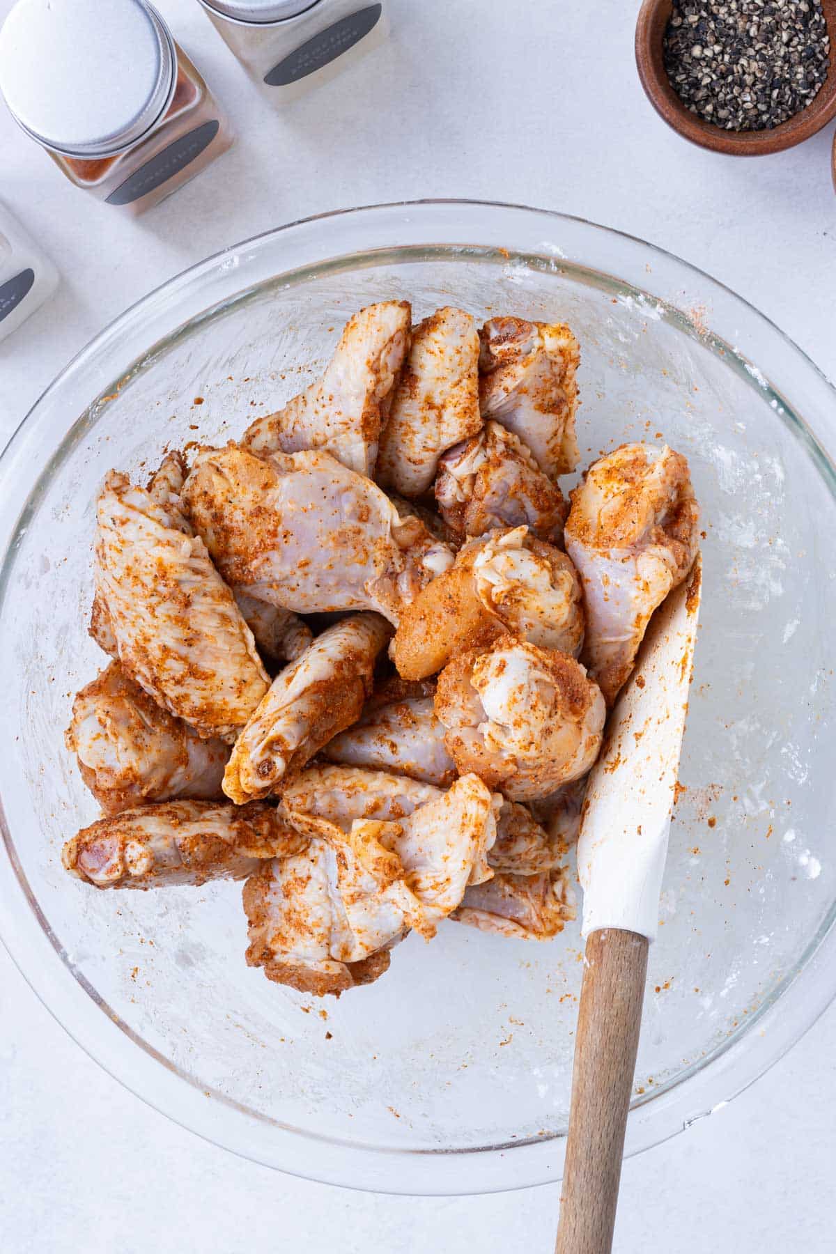 Wings are tossed in seasoning.