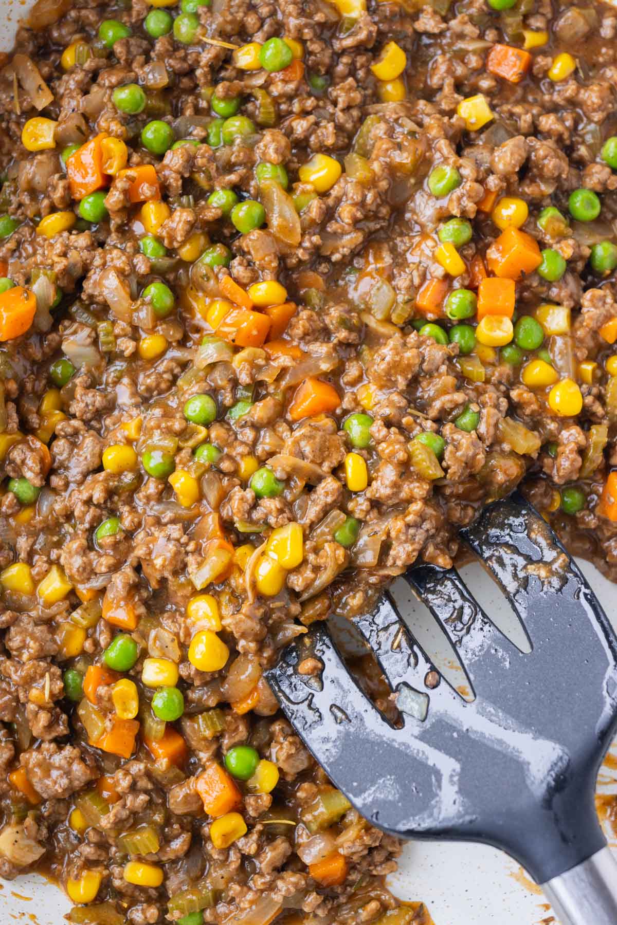 The ground beef filling for the Mini Shepherd's Pies is cooked in a skillet until thick.