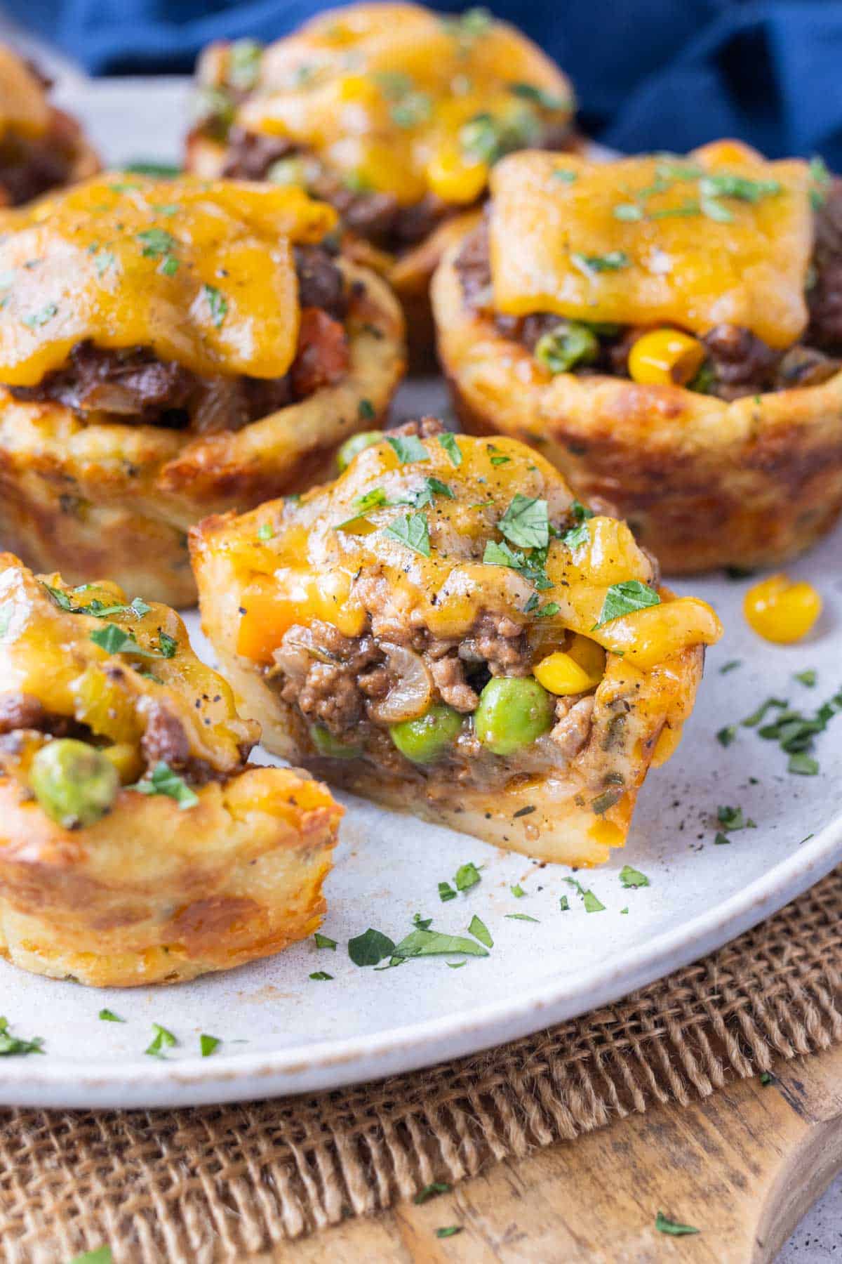 A mini shepherd's pie is cut in half to show the potato crust and the ground beef filling.